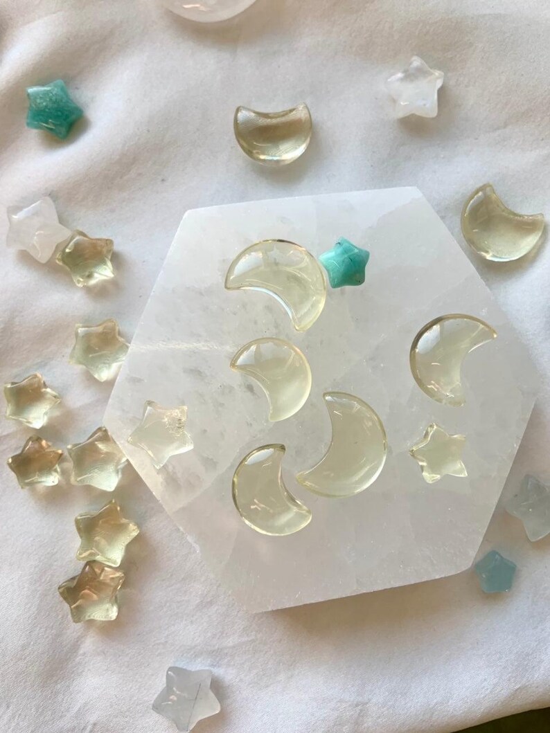 Mini Lemon Citrine moons and stars displayed with Clear Quartz points and celestial crystals on a Selenite plate