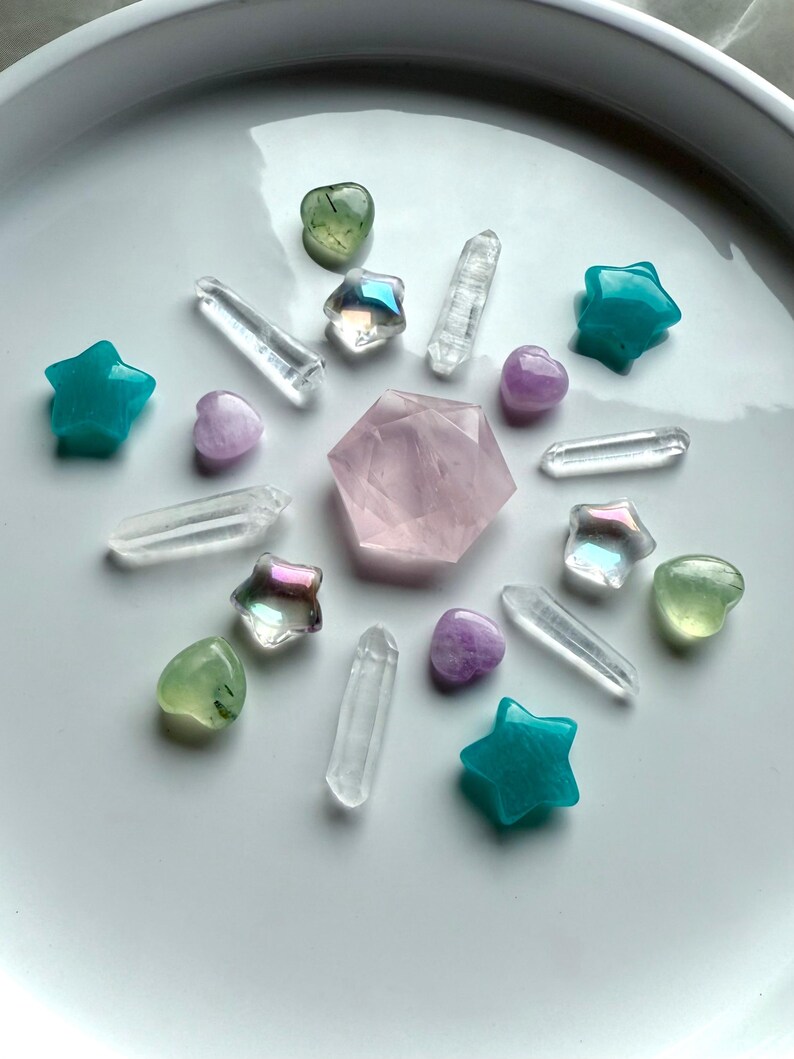 Mini crystal carvings arranged in a healing crystal grid with Prehnite hearts featuring Epidote inclusions, Kunzite, Aura Quartz, Amazonite, Rose Quartz hexagon, and clear Quartz points for chakra balance, love, and clarity.