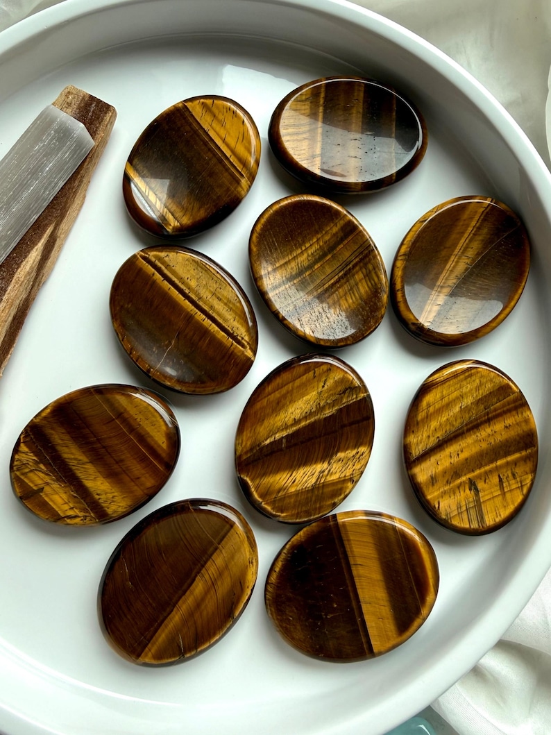 top view of tiger’s eye thumb stones in bowl with rich golden brown tones, worry stones for confidence grounding and focus