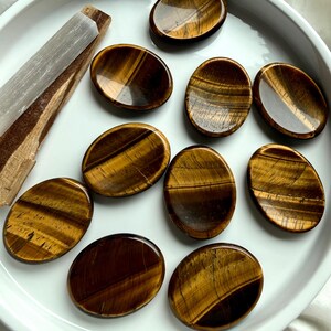 tiger’s eye oval worry stones arranged in ceramic dish, polished thumb stones for protection focus and personal power