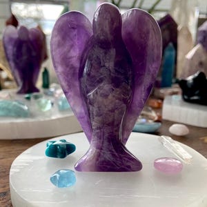 Selenite plate used as altar base for amethyst angel carving with mini celestial crystal accents