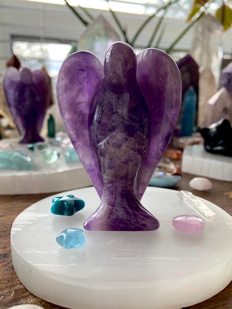 Selenite plate used as altar base for amethyst angel carving with mini celestial crystal accents