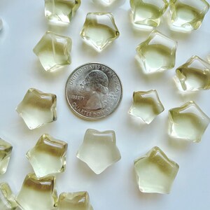 Mini Lemon Citrine stars shown with a US quarter to show their petite scale and golden-yellow color