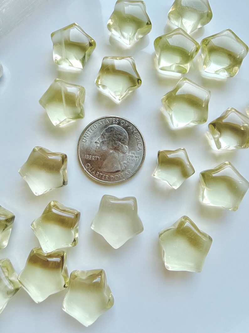 Mini Lemon Citrine stars shown with a US quarter to show their petite scale and golden-yellow color
