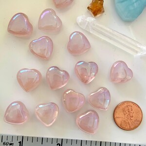 Mini angel aura rose quartz hearts shown with measuring tape & penny for size reference — glowing pink crystals for heart chakra healing & love