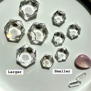 Peut inclure: Une collection de cristaux de quartz transparents de diff&eacute;rentes tailles, les plus grands &eacute;tant &eacute;tiquet&eacute;s "Larger" et les plus petits "Smaller".