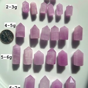 Puede incluir: Una colecci&oacute;n de 18 puntas de amatista p&uacute;rpura, que van de 1 a 2 gramos a 6 a 7 gramos. Las puntas est&aacute;n dispuestas en filas, con las puntas m&aacute;s peque&ntilde;as en la parte superior y las puntas m&aacute;s grandes en la parte inferior.