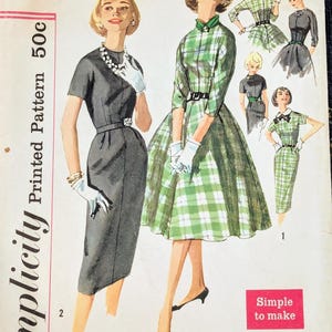 May include: A Simplicity sewing pattern envelope 2646 for a miss size 14, bust 34. The cover features illustrations of two dresses: one solid dark gray sheath dress and one green and white plaid dress with a full skirt, both with belts.