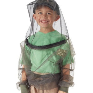 May include: A child wearing a black and grey bug-proof mesh suit with a zipped front and a hood. The suit has long sleeves and elastic cuffs. The suit has a label that says "Bug Baffler".