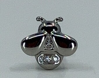 May include: A silver bee charm with three clear rhinestones. The bee is detailed with a textured body and wings.