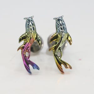 May include: A pair of rainbow iridescent koi fish earrings. The fish are detailed with scales and have a silver finish.