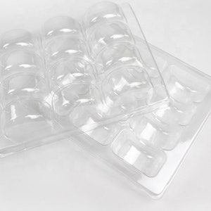 May include: Two clear plastic trays with multiple compartments for holding small items. The trays are stacked on top of each other.