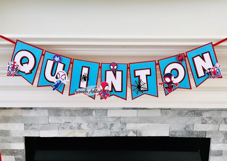 K&ouml;nnte beinhalten: Ein blaues und rotes Banner mit dem Namen "QUINTIN" in wei&szlig;en Buchstaben. An jedem Buchstaben ist ein kleiner Spiderman-Charakter befestigt.