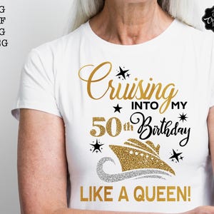 Pode incluir: Camiseta branca com texto dourado e preto: "Cruising into my 50th Birthday Like a Queen!". Um gr&aacute;fico de navio de cruzeiro com glitter dourado &eacute; apresentado abaixo do texto, com estrelas e uma onda prateada.