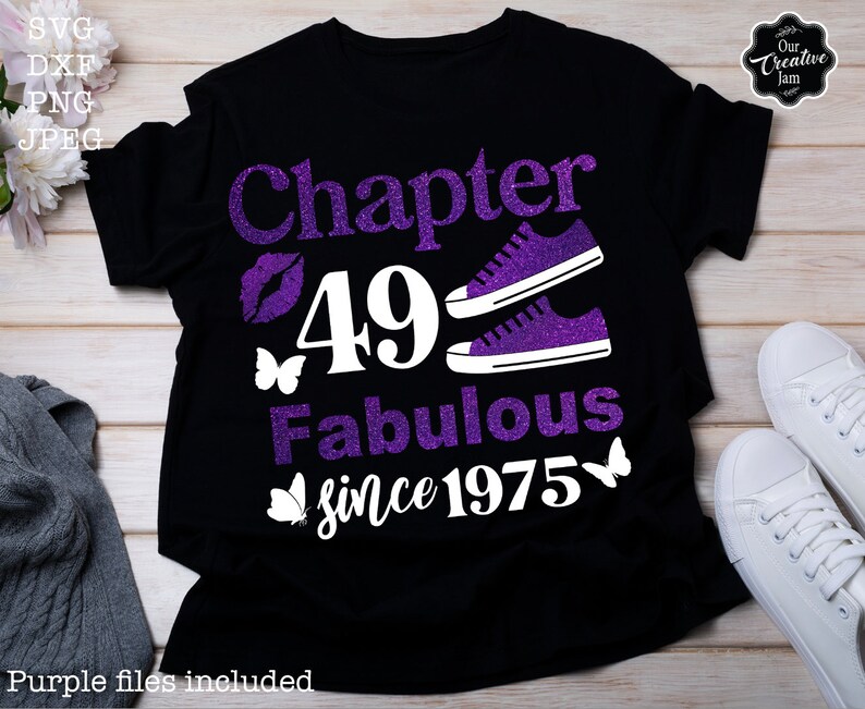 May include: A black t-shirt with a purple glitter design that says "Chapter 49 Fabulous since 1975". The design also includes a pair of purple glitter sneakers, a butterfly, and a lip print.