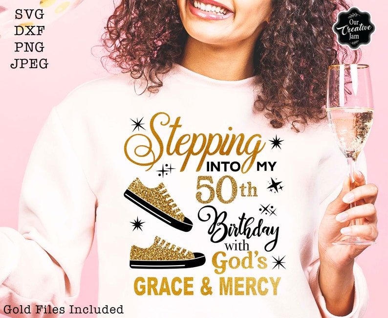 May include: A white sweatshirt with gold glitter lettering that says "Stepping into my 50th Birthday with God's Grace & Mercy". The text is surrounded by gold glitter stars and two gold glitter trainers.