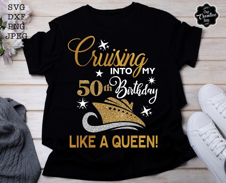 Pode incluir: Camiseta preta com texto dourado brilhante que diz "Cruising into my 50th Birthday like a Queen!". O design inclui um gr&aacute;fico de navio de cruzeiro. T&ecirc;nis brancos s&atilde;o vis&iacute;veis &agrave; direita. A camiseta &eacute; de estilo casual.