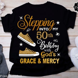 May include: Black t-shirt with gold glitter text that reads "Stepping into my 50th Birthday with God's Grace & Mercy". The text is surrounded by gold glitter stars and two gold glitter sneakers.