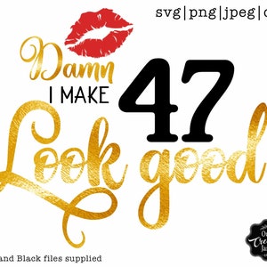 以下が含まれることがあります： 赤い唇のプリントと「Damn I make 47 look good」というテキストが入った、金色と黒色のグラフィックデザインです。
