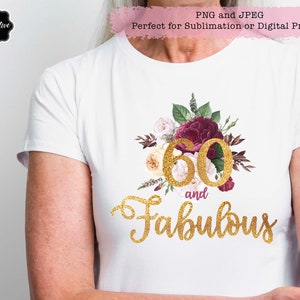 May include: White t-shirt with a gold glitter design that says "60 and Fabulous". The number 60 is surrounded by burgundy and white flowers.