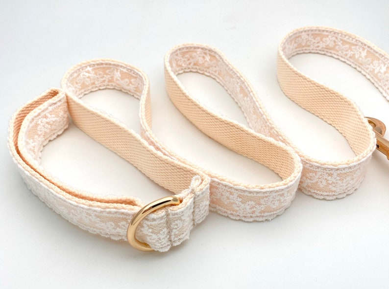 May include: A beige dog lead with white lace trim and a gold metal clasp.