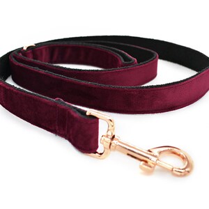 May include: A burgundy velvet dog leash with a rose gold hook.