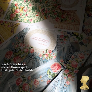 May include: A light blue paper dress with a floral design and the quote "I must have flowers, always, and always." by Claude Monet. The text "Each dress has a secret flower quote that gets folded inside." is also visible.
