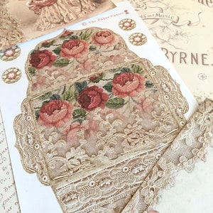 May include: A vintage-style card with a delicate lace design and embroidered floral motifs in shades of pink and green. The card features the text "Love You'll Be True" and "The Paper Cameo".