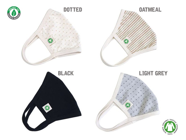May include: Four different fabric face masks with a white border. The masks are in the colours black, light grey, oatmeal, and white with a dotted pattern. Each mask has a green logo with a leaf and the text "Organic 100" and "Global Organic Textile Standard GOTS".