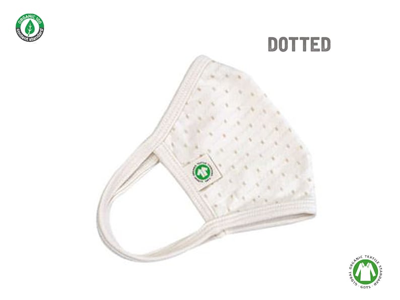 May include: A white face mask with a dotted pattern. The mask has a small green logo with a tree on it. The text "DOTTED" is printed in black above the mask.