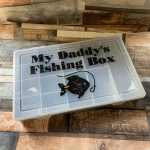 May include: A clear plastic tackle box with a black and iridescent fish graphic and the text "My Daddy's Fishing Box".