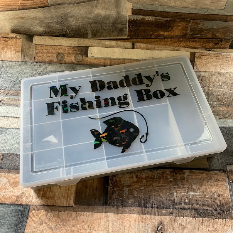 May include: A clear plastic tackle box with a black and iridescent fish graphic and the text "My Daddy's Fishing Box".