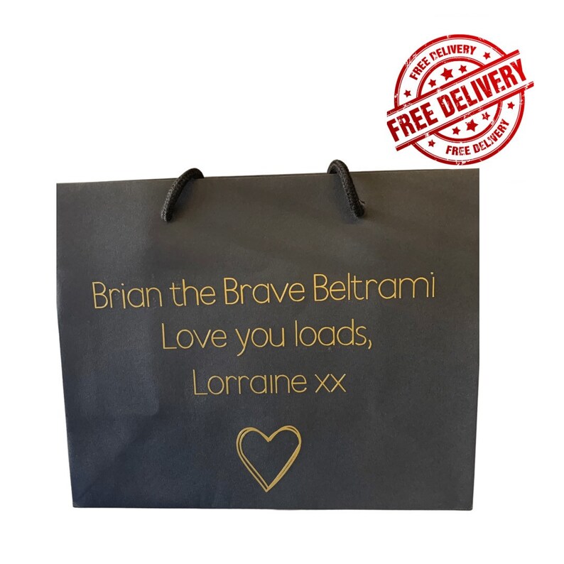 May include: A black gift bag with a gold heart and the text "Brian the Brave Beltrami Love you loads, Lorraine xx" printed on the front.