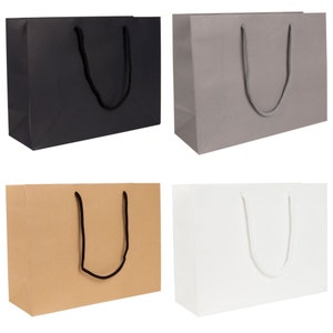 May include: Four paper gift bags in different colours: black, grey, brown, and white. Each bag has a pair of rope handles.
