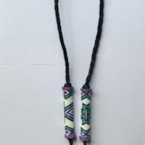 May include: A black braided lanyard with decorative beaded sections. The beaded sections feature white, purple, teal, and pink geometric patterns. A purple leather strap and silver keyring are attached at the bottom.