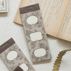 May include: Floral patterned sticky notes with a brown top edge. The notes have a beige background with a repeating floral design and three white label shapes. The text "LOI" is printed on each label.