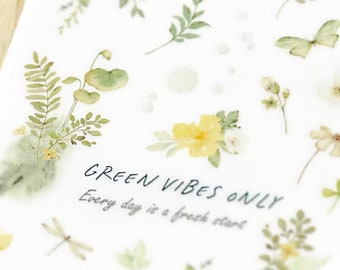 May include: A sheet of clear stickers with pressed flowers and leaves. The stickers feature a variety of floral designs, including yellow flowers, green leaves, and a butterfly. The sheet also includes the text "GREEN VIBES ONLY" and "Every day is a fresh start."