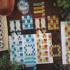 May include: A set of colourful floral patterned stickers with various shapes and sizes. The stickers include frames, borders, circles, and rectangles. The stickers are on a white background.