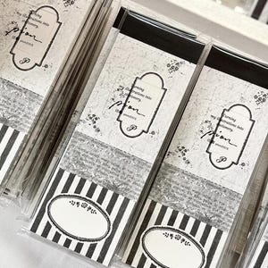 May include: A set of rectangular stationery packs in clear plastic sleeves. Each pack features a white label with the text 'Turning my illustrations into stationery', 'pion', and 'pion2015'. Below is a vintage-style paper design and a black and white striped section with an oval frame containing a small floral illustration.