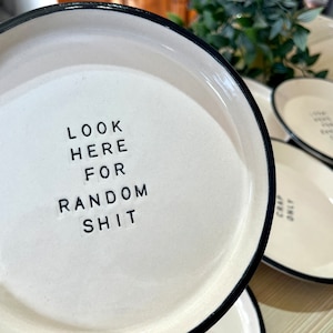Może przedstawiać: Biała ceramiczna miska z czarnym rantem. Miska ma nadrukowany tekst "LOOK HERE FOR RANDOM SHIT".