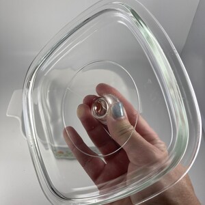 Pu&ograve; includere: Coperchio in vetro trasparente per una pirofila quadrata. Il coperchio ha un piccolo pomo in cima.