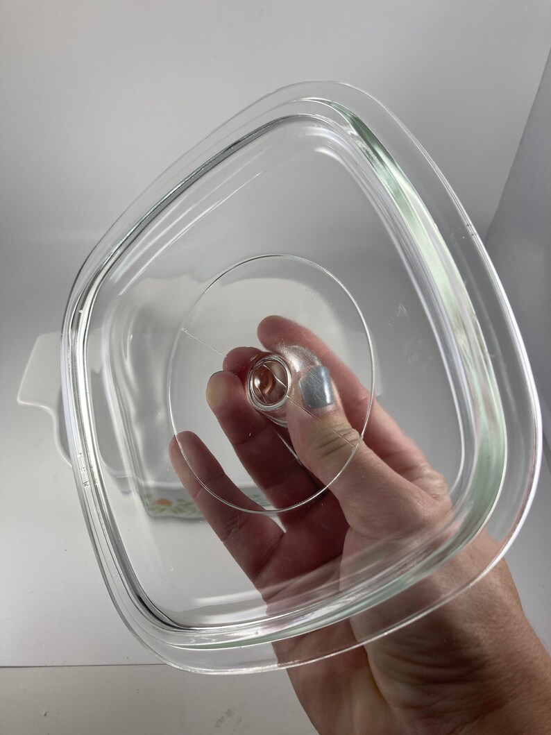Pu&ograve; includere: Coperchio in vetro trasparente per una pirofila quadrata. Il coperchio ha un piccolo pomo in cima.