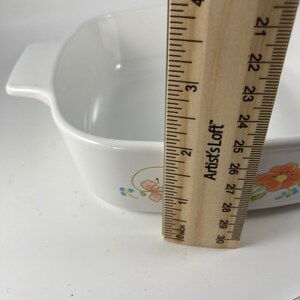 Pu&ograve; includere: Piatto da forno in ceramica bianca con un motivo floreale in tonalit&agrave; rosa, blu e giallo. Il piatto &egrave; largo 18 cm e ha un manico su ogni lato.