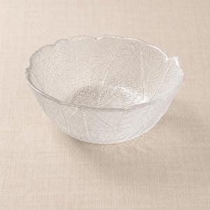 May include: Clear glass bowl with a leaf design. The bowl has a textured surface and a scalloped rim. The leaf pattern is visible throughout the bowl, adding a natural aesthetic. The bowl is suitable for serving salads or displaying decorative items.