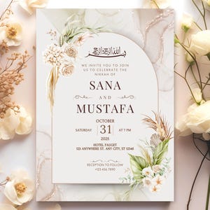 May include: An invitation card with floral and gold accents. The card features the names "Sana" and "Mustafa", with the date "October 31, 2025" and the time "7 PM". The card is surrounded by white flowers and foliage.