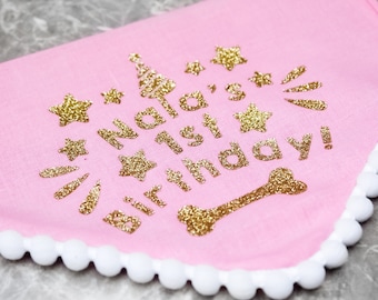 May include: Pink fabric dog collar with a gold glitter design that says "Nala's 1st Birthday!" with stars and a bone.