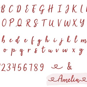 K&ouml;nnte beinhalten: Handgeschriebenes Alphabet in Rot mit Gro&szlig;- und Kleinbuchstaben, Zahlen von 0 bis 9, kaufm&auml;nnischem Und-Zeichen und Herzsymbol. Der Name Amelia ist in Kursivschrift mit Herzen auf beiden Seiten geschrieben.