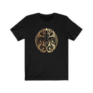 May include: A black t-shirt with a gold and brown circular design featuring intricate swirls and patterns.