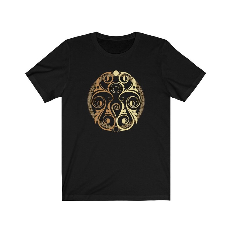 May include: A black t-shirt with a gold and brown circular design featuring intricate swirls and patterns.