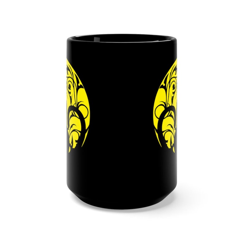 May include: Black ceramic mug with a yellow design of a stylised floral pattern on each side.